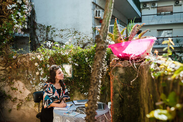 adult woman artist sitting on the terrace of her house drawing inspired.