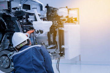 The asian technician repairing or modify the car's engine in the garage. the concept of automotive, repairing, mechanical, vehicle and technology.