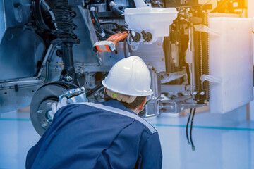 The asian technician repairing or modify the car's engine in the garage. the concept of automotive, repairing, mechanical, vehicle and technology.