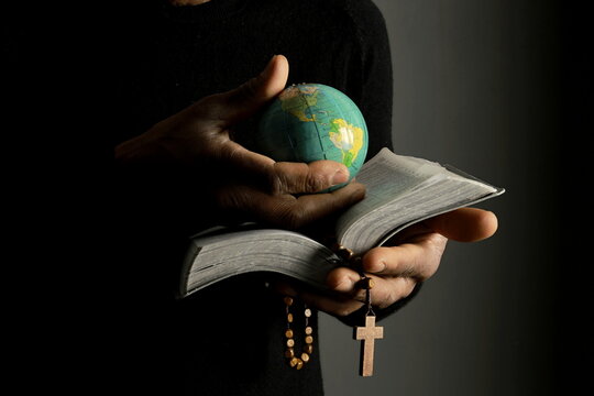 praying to God with hands together with black background stock photo