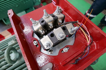 An induction motor's terminal block showing the wires connected to the windings inside the motor's stator. Industrial maintenance and technology work concept