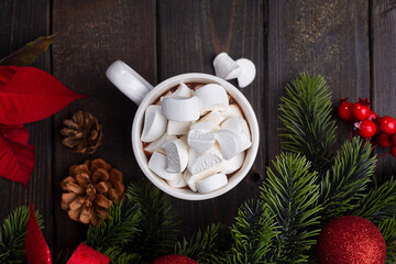 Red mug with hot chocolate on top of which pieces of marshmallows float, top view 