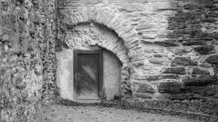 Wooden gate in old walls black and white