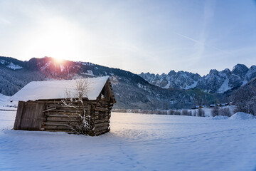 wooden cabin next to the Dachstein mountins in Gosau with sunlight