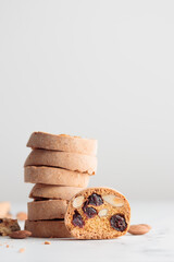 Stack of biscotti cantucci cookies with almond and cranberry on white background