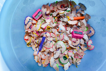 pencil sharpener and crayon shavings and crayons that are no longer used in bin