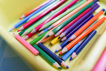 Several colored pencils placed in plastic box.