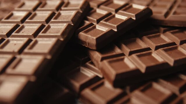 Close-up slide camera chocolate bar pattern, lot of homemade chocolate bars. Handmade chocolate grid texture dolly sliding shot. Confectionery manufacture