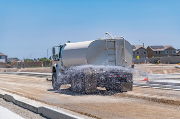 The watering machine waters the road. Road construction. Repair.
