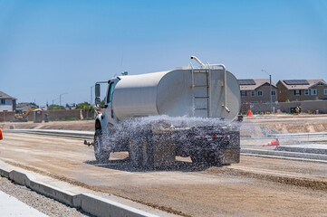 The watering machine waters the road. Road construction. Repair.