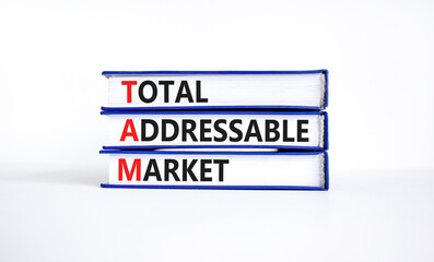 TAM total addressable market symbol. Concept words TAM total addressable market on books on a beautiful white table white background. Business TAM total addressable market concept. Copy space.