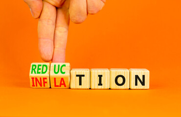 Inflation or reduction symbol. Concept word Inflation Reduction on wooden cubes. Businessman hand. Beautiful orange table orange background. Business inflation or reduction concept. Copy space.