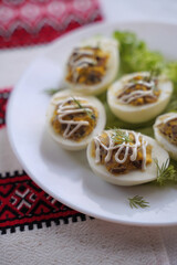 Deviled eggs aka stuffed eggs. Traditional Ukrainian food on the table with embroidered tablecloth.