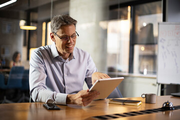 Obraz premium Portrait of businessman in office. Man using digital tablet. Businessman having video call..