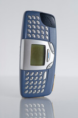 Retro blue smart mobile cell phone classic 1990s with qwerty keyboard isolated