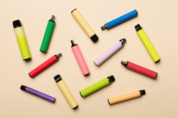 Disposable electronic cigarettes on color background, top view