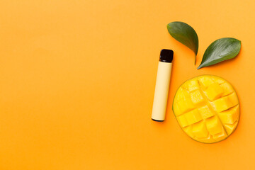 Disposable electronic cigarettes with mango fruit on color background, top view