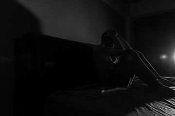 Man with depression sitting in a dark room.  Depression is a low mood that lasts for a long time,...