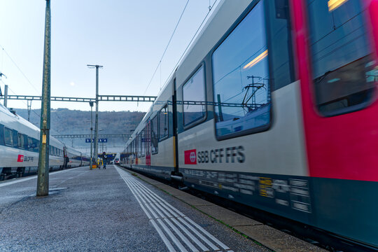 White and red SBB train leaving railway station of Swiss City Biel Bienne on a blue cloudy autumn day. Photo taken November 10th, 2022, Biel Bienne, Switzerland