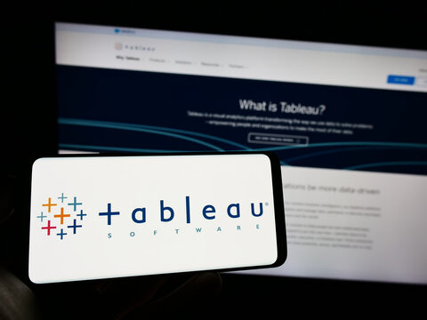 Stuttgart, Germany - 12-30-2022: Person holding cellphone with logo of US company Tableau Software Inc. on screen in front of business webpage. Focus on phone display.