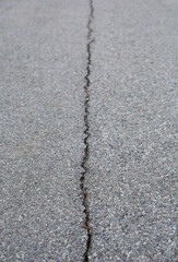 Cracked on asphalt road background.