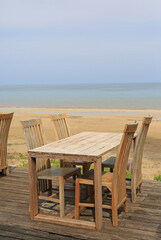 Empty wood table and chairs at restaurants near the beach.