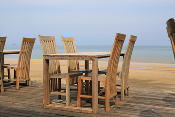 Empty wood table and chairs at restaurants near the beach.
