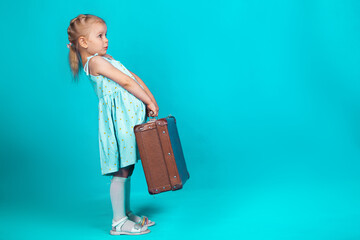 a girl on a blue background with a suitcase in her hands