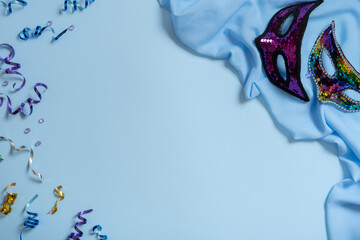 Festive face mask for carnival celebration on colored background. Carnival flat lay concept