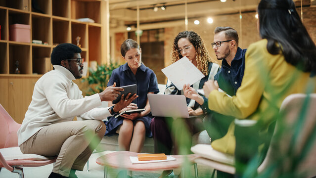 Female Manager Leading a Meeting About Sustainability and Ethnicity with her Multiethnic Teammates. Young Group of Employees Presenting Their Project Ideas To Startup CEO. Medium Shot - Powered by Adobe