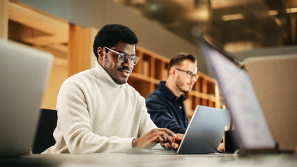 Portrait of Enthusiastic Black Man Turning on his Laptop and Starting his Work Day at the Office....