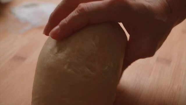 Women's hand quickly shaping dough into a round (boule)