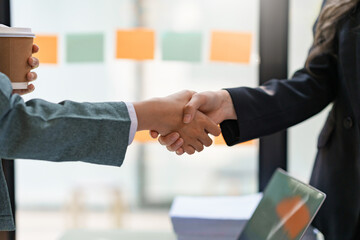 Business People standing, congratulating shaking hands confirming the agreement of doing business...