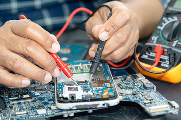 Technician repairing inside of mobile phone. Integrated Circuit. the concept of data, hardware,...