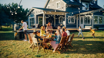 Parents, Children and Friends Gathered at a Barbecue Dinner Table Outside a Beautiful Home. Old and...
