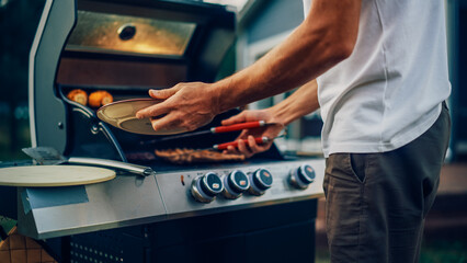 Close Up Man Preparing Grilled Meat Steak on a Fire Grill. Young Man Grilling Food for Outdoors Barbecue Dinner for Family.