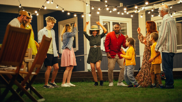 Parents, Children and Multicultural Friends Dancing Together at a Garden Party Disco Event at Home. Young and Senior People Relaxing, Having Fun on a Summer Evening.