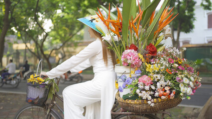 Portrait of Asian peddler with bike and flowers, Vietnamese woman girl traveling in Hanoi urban city town, Vietnam. People lifestyle. - obrazy, fototapety, plakaty