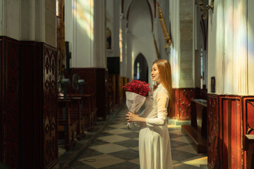 Asian Vietnamese woman praying in empty christian church with cross, architecture design. Religious beliefs. Catholic religion. Jesus worship. People lifestyle.