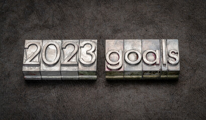 Naklejka premium 2023 goals in grunge metal type against black textured paper, setting goals and resolutions concept