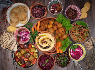 Fototapeta na wymiar Vegetarian mezze spread consisting of falafel, crudites, tabbouleh, cheese, olives and pickles 