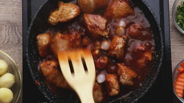 cooking meat burgundy in red tomato sauce