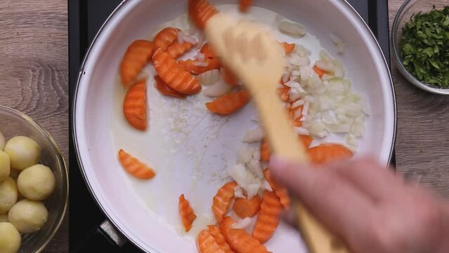 fry chopped onions and carrots in oil