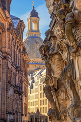 Cityscape - street view with sculptures of gatekeepers on the George Gate of Dresden Castle against...