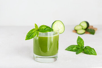 Fresh cucumber lemonade with basil and lemon in a glass.