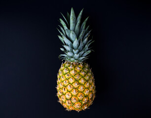 Pineapple on the black background. Copy space. Close-up.