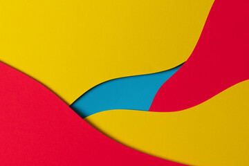 Abstract colored paper texture background. Minimal paper cut style composition with layers of geometric shapes and lines in yellow, red and light blue colors. Top view