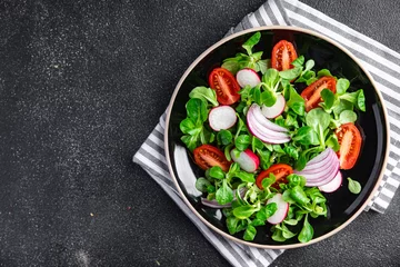 Fotobehang vegetables salad tomato, radish, onion, mache lettuce, green leaves spring snack fresh healthy meal food on the table copy space food background rustic top view keto or paleo diet veggie vegan  © Alesia Berlezova