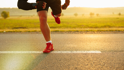 Detailed view of a sprinter getting ready to start. Selective focus.Beautiful field and light sun...