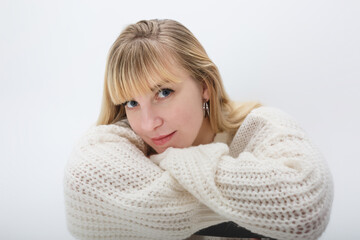 close up portrait of blonde girl model in white wool sweater on white background in studio